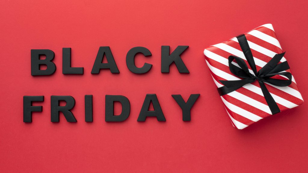 Black Friday Tekst „Black Friday“ punasel taustal, kõrval kinkekarp.