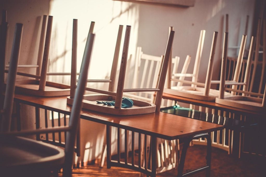 Pusta klasa z krzesłami ustawionymi na ławkach po zakończeniu roku szkolnego.