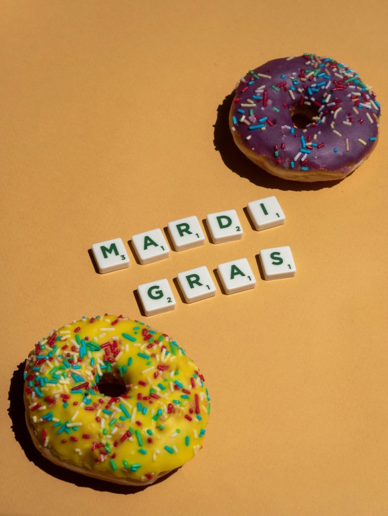 Donuty z kolorową polewą i napisem „Mardi Gras”, międzynarodowe obchody karnawału.