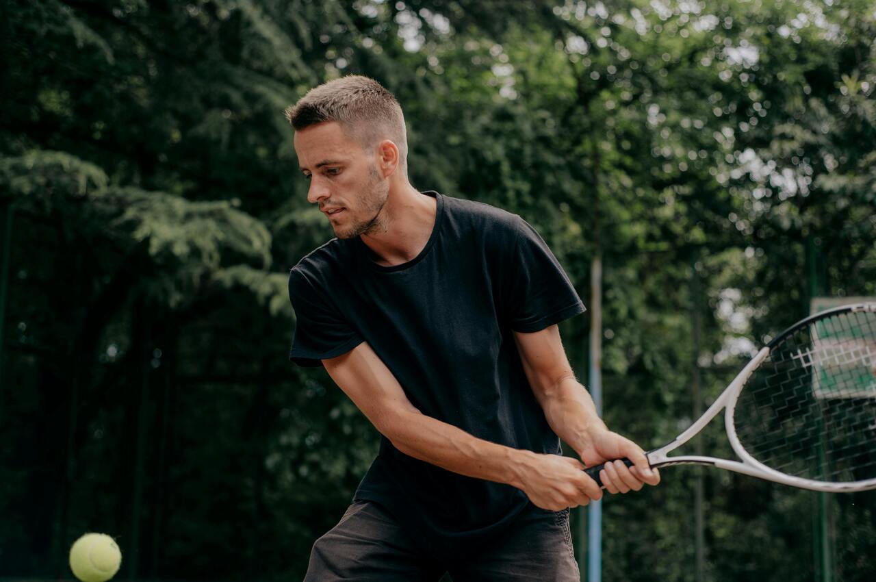 tenis - zasady gry i ciekawostki, mężczyzna z rakietą tenisową, odbija piłkę 