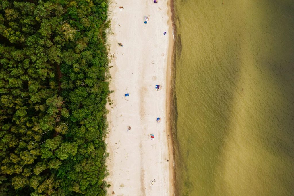 widok z lotu ptaka na mało zatłoczoną plażę nad Morzem Bałtyckim.