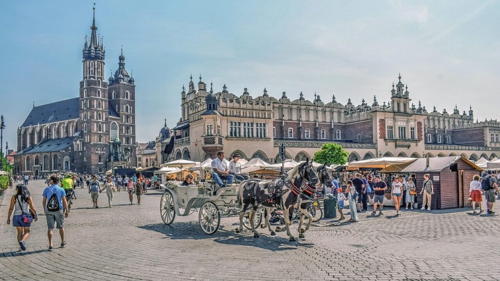 Rynek w Krakowie to idealne miejsce na weekend z dziećmi w mieście. Dorożka, turyści, lato.