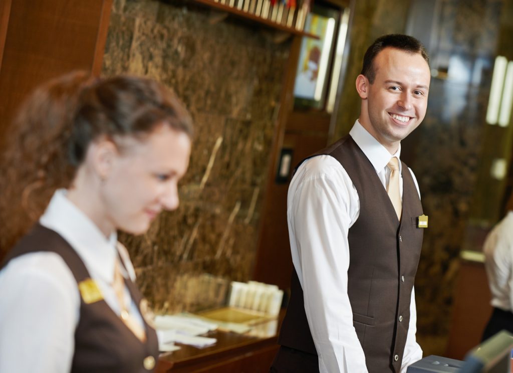 Kobieta i mężczyzna - recepcjoniści w hotelu.