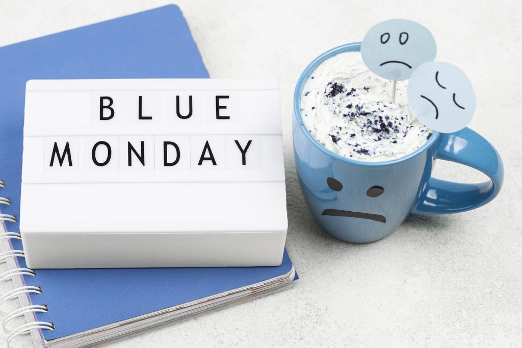 Co to jest Blue Monday – kubek z ponurą buźką i napisem Blue Monday, symbol najbardziej depresyjnego dnia w roku.