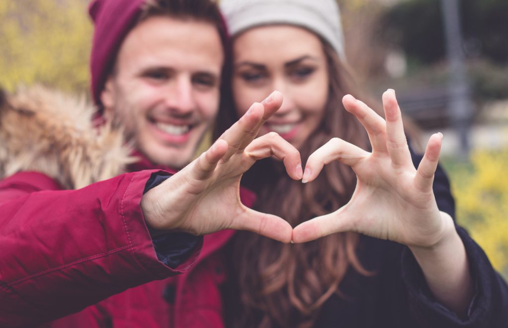 Kiedy są walentynki – zakochana para tworzy serce dłońmi.